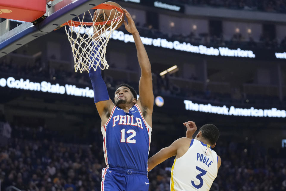 Philadelphia 76ers forward Tobias Harris (12) dunks over Golden State Warriors guard Jordan Poole (3) during the first half of an NBA basketball game in San Francisco, Friday, March 24, 2023. (AP Photo/Jeff Chiu)