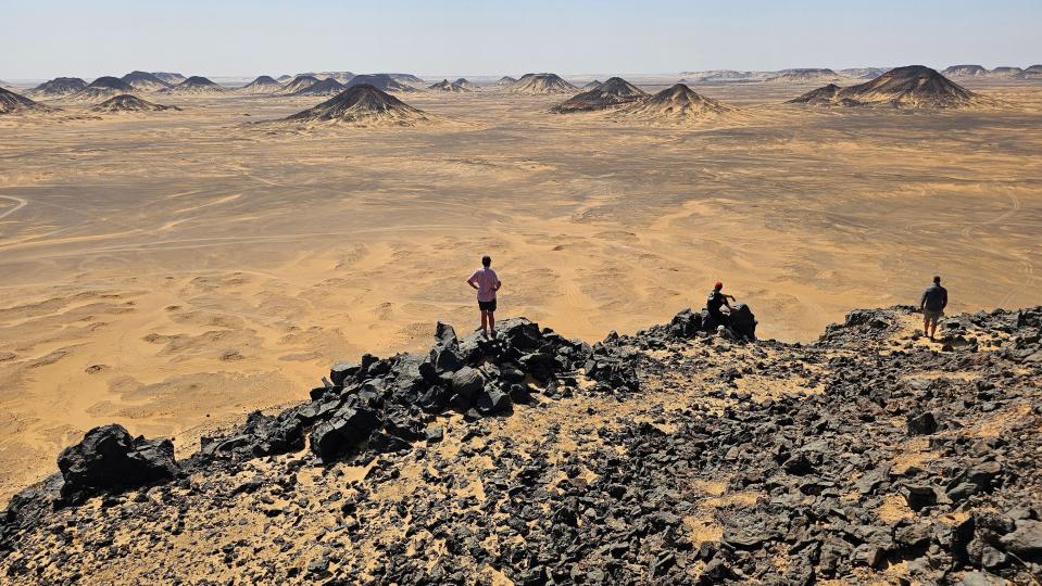 Three people looking out across the desert in Egypt