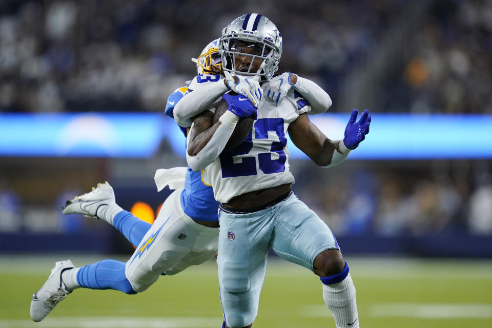 Dallas Cowboys running back Rico Dowdle is tackled by Los Angeles Chargers cornerback Brandon Sebastian during the first half of a preseason NFL football game Saturday, Aug. 20, 2022, in Inglewood, Calif. (AP Photo/Ashley Landis)