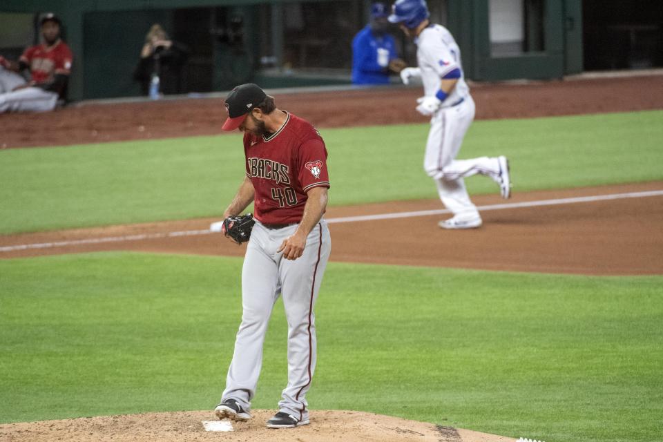 Arizona Diamondbacks starting pitcher Madison Bumgarner kicks dirt off the pitching rubber after giving up a solo home run to Texas Rangers' Todd Frazier, background, during the fourth inning of a baseball game Wednesday, July 29, 2020, in Arlington, Texas. (AP Photo/Jeffrey McWhorter)