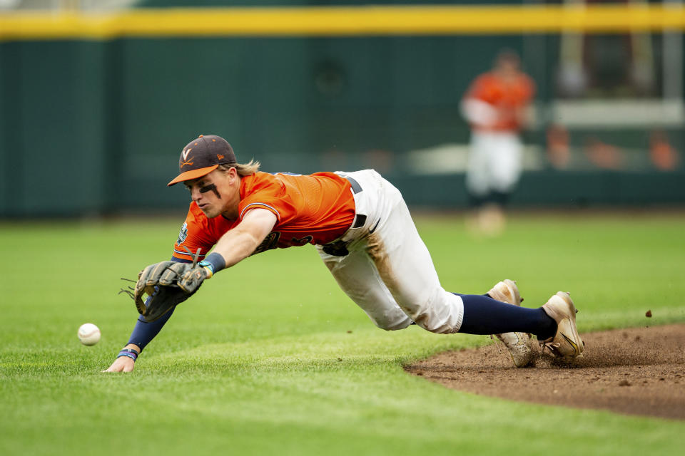 Virginia shortstop Griff O'Ferrall dives for the ball against Florida in the second inning of a baseball game at the NCAA College World Series in Omaha, Neb., Friday, June 16, 2023. (AP Photo/John Peterson)
