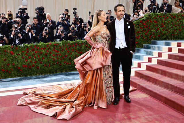 <p>Jamie McCarthy/Getty</p> Blake Lively wearing a custom Atelier Versace gown alongside husband Ryan Reynolds at the 2022 Met Gala