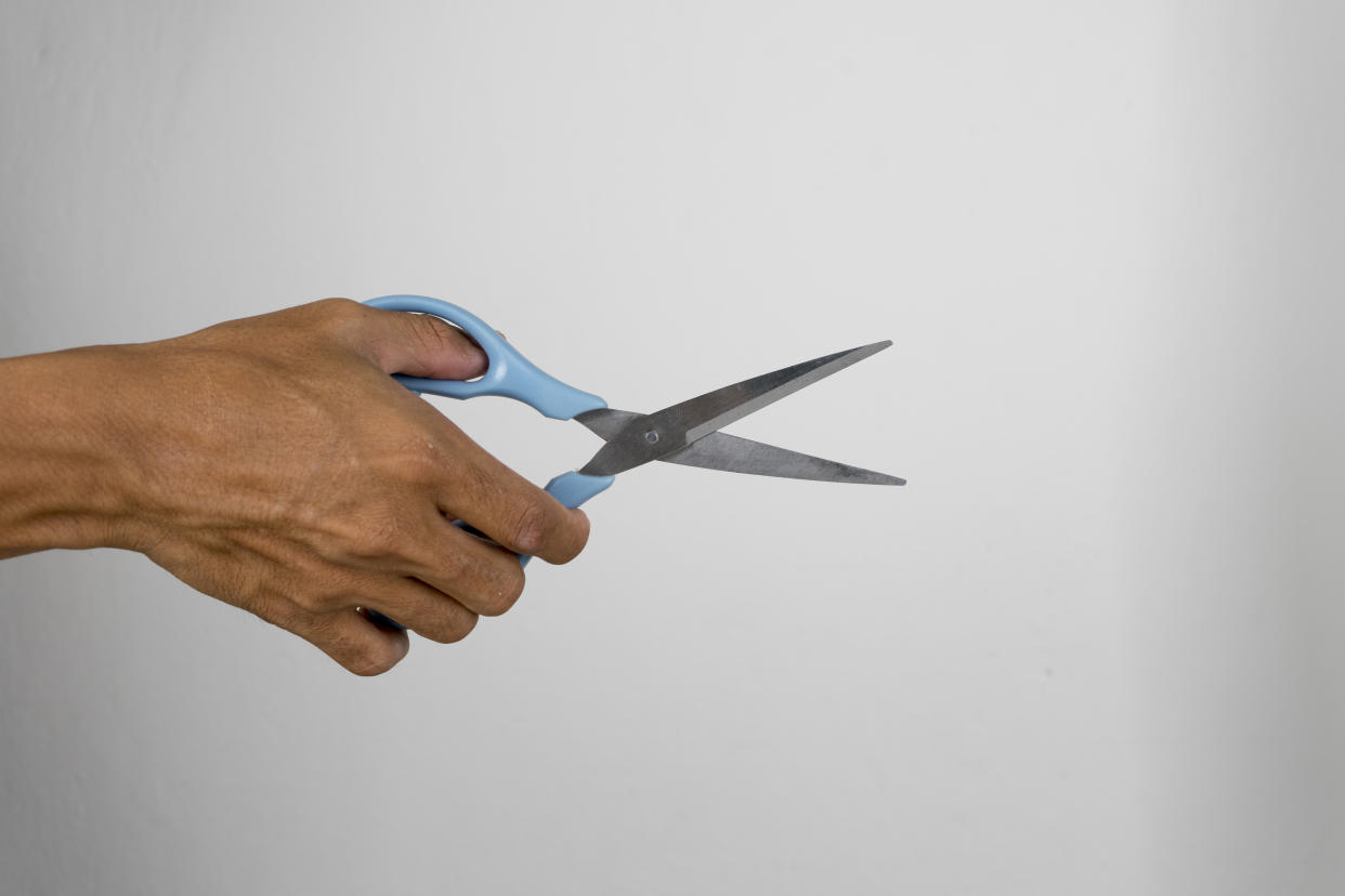 holding scissors in white background