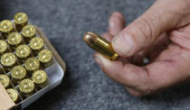 In this photo taken Tuesday, June 11, 2019, Chris Puehse, owner of Foothill Ammo displays a .45 caliber bullet for sell at his store in Shingle Springs, Calif. Californians will have to undergo criminal background checks every time they buy ammunition starting July 1 under a 2016 voter-approved ballot initiative. (AP Photo/Rich Pedroncelli)