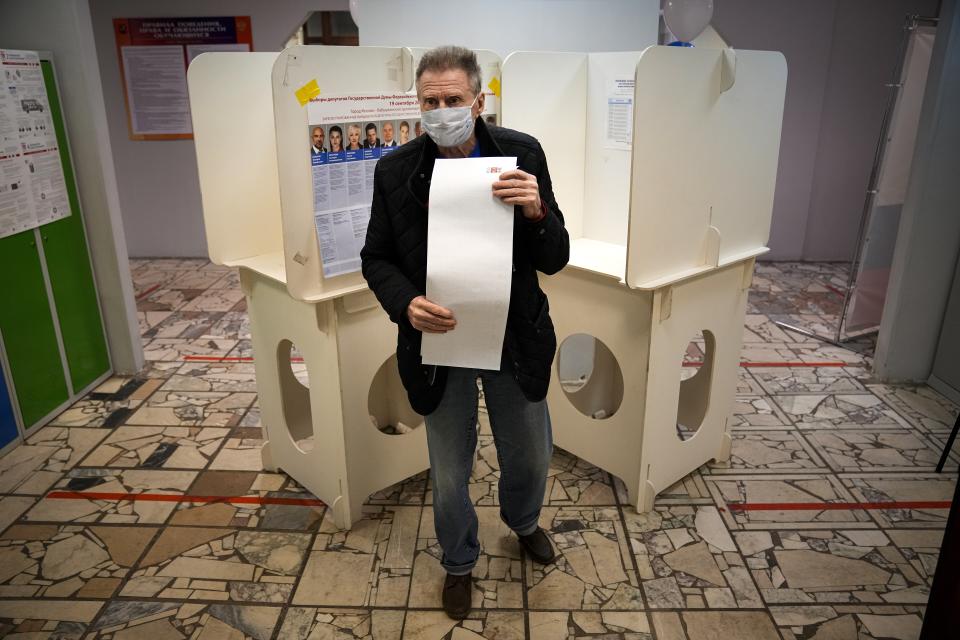 A man walks to casts his ballot at a polling station during Parliamentary elections in Moscow, Russia, Friday, Sept. 17, 2021. Russia has begun three days of voting for a new parliament that is unlikely to change the country's political complexion. There's no expectation that United Russia, the party devoted to President Vladimir Putin, will lose its dominance in the State Duma. (AP Photo/Alexander Zemlianichenko)