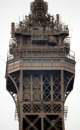 An unidentified man climbs the Eiffel Tower, which had to be evacuated, close to Paris fire brigade specialists in Paris, France, May 20, 2019. REUTERS/Charles Platiau