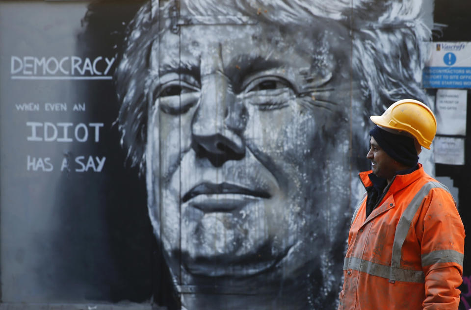 <p>A construction worker stands in front of a piece of street art portraying Donald Trump in east London, Jan. 28, 2016. (Andrew Winning/Reuters) </p>