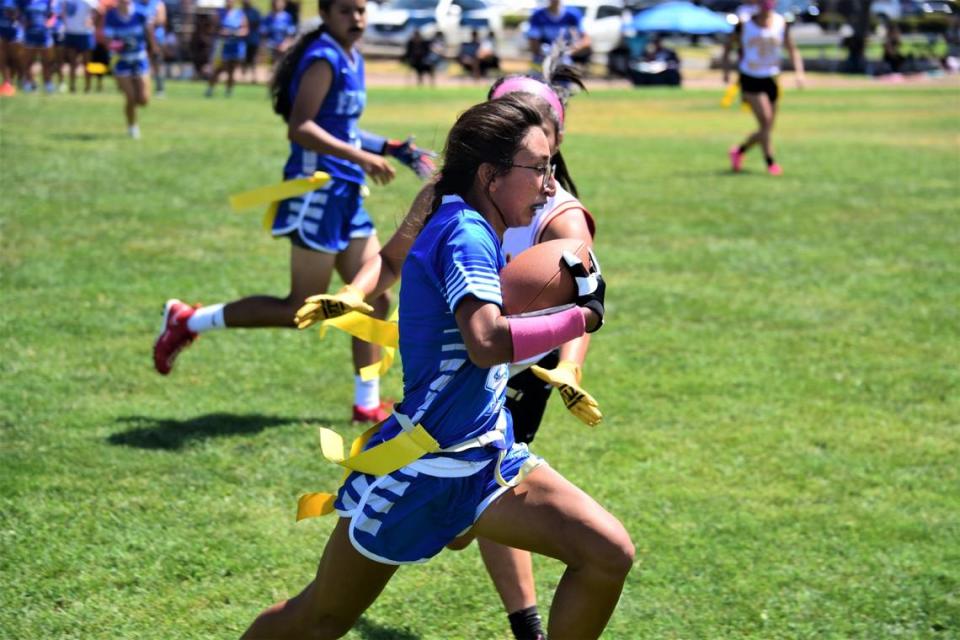Atwater High School senior Nayeli Garcia runs will the ball during a flag football game against Golden Valley on Saturday, Aug. 19, 2023 at Merced High School in Merced, Calif.