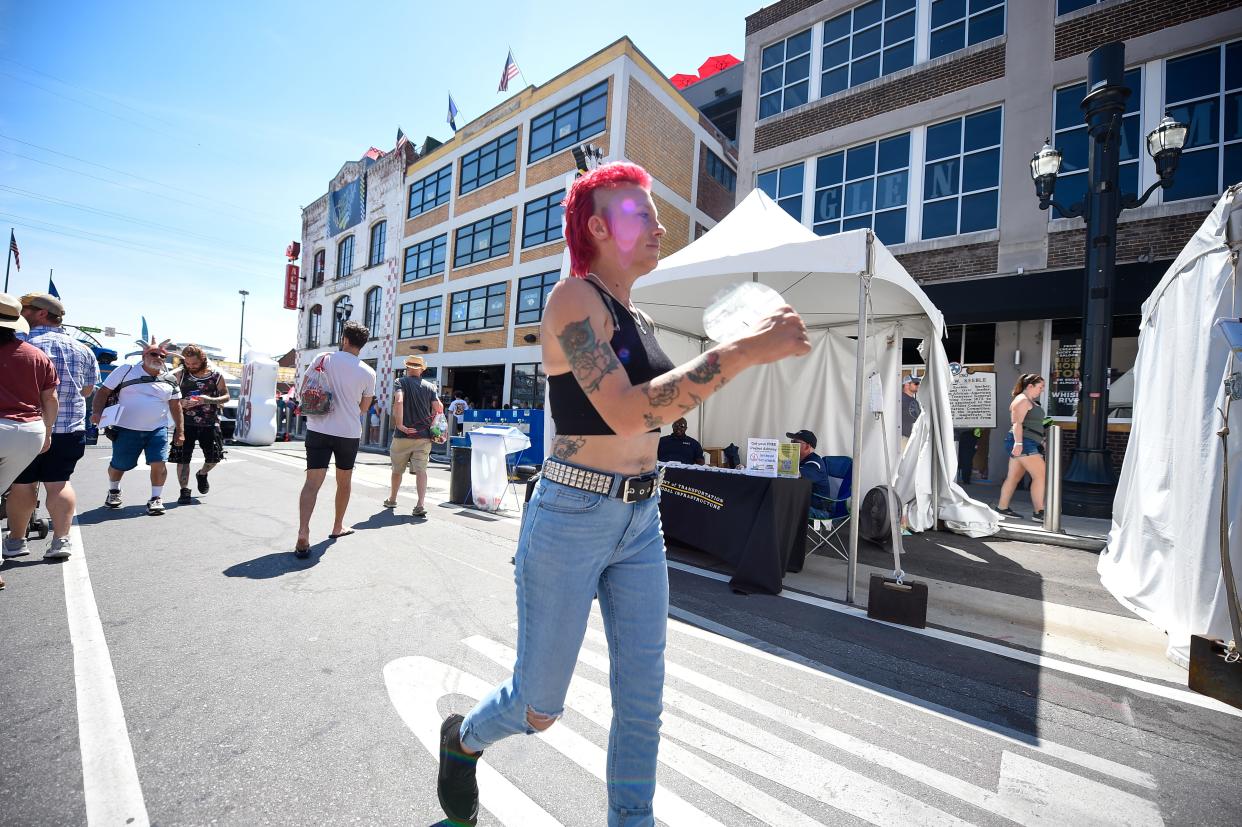 A person cools off with a fan on broadway during the CMA Fest in Nashville, Tenn., Saturday, June 11, 2022.