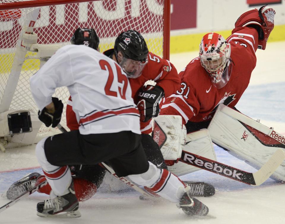 Canadian goalie Zachary Fucale makes a save against Switzerland during first period action in a quarterfinal match at the world junior hockey tournament in Malmo, Sweden, Thursday, Jan 2, 2014. At left is Switzerland's Dario Simion (25) and at center is Canada's Aaron Ekblad (5). AP Photo/The Canadian Press, Frank Gunn)