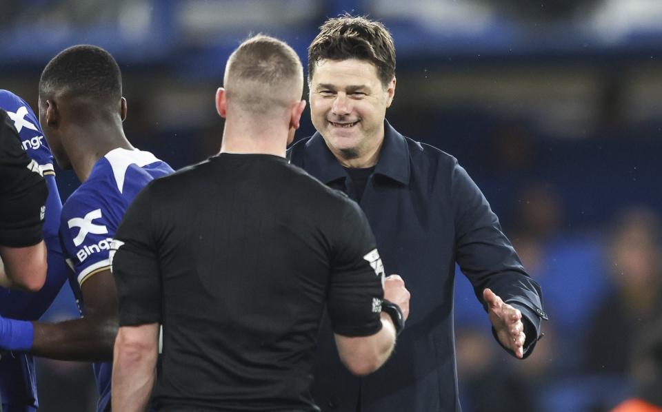 A beaming Mauricio Pochettino shakes hands with the referee