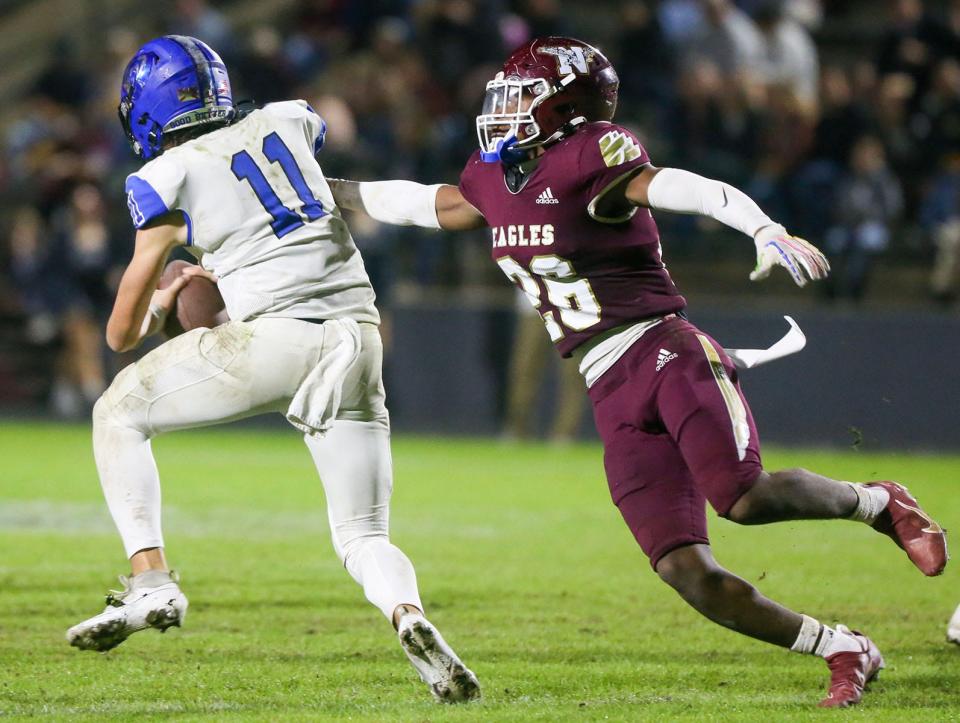 Bartram Trail quarterback Riley Trujillo (11) spins away from Niceville safety Alante Reese on Friday. The Bears became Northeast Florida's first-ever team to win consecutive road football playoffs in the Central Standard Time zone.