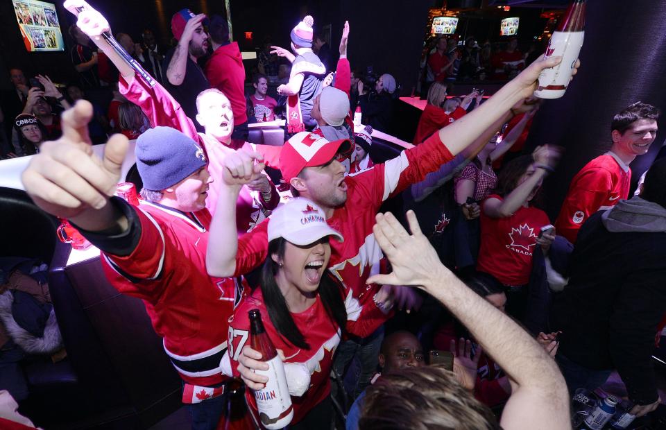 Fans celebrate Team Canada's gold medal win over Sweden in their men's ice hockey game at the Sochi 2014 Winter Olympic Games, at a gathering in Toronto February 23, 2014. REUTERS/Aaron Harris (CANADA - Tags: SPORT OLYMPICS ICE HOCKEY)