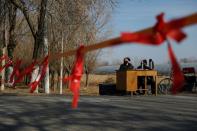 Community members guard at the entrance of a community to prevent outsiders from entering, as the country is hit by an outbreak of the new coronavirus, on outskirts of Beijing