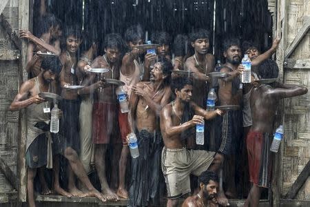 Migrants collect rainwater at a temporary refugee camp near Kanyin Chaung jetty, in Myanmar June 4, 2015. REUTERS/Soe Zeya Tun