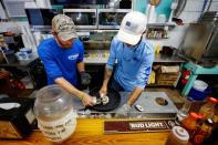 Brandon Martina and Michael Braswell of Lynn's Quality Oysters shuck oysters from Texas for waiting diners at the restaurant in Eastpoint, Florida