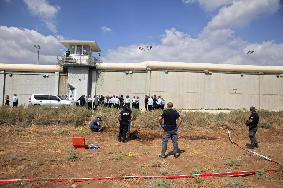 FILE - In this Monday, Sept. 6, 2021 file photo, police officers and prison guards inspect the scene of a prison escape by six Palestinian prisoners, outside the Gilboa prison in Northern Israel. Pressure is building around Israel's prison system after fires broke out at several facilities and the government hunted for six Palestinian escapees who have been on the run since they tunneled out two days earlier. Fires were reported at several prisons Wednesday amid efforts to try to move inmates as a precautionary measure. (AP Photo/Sebastian Scheiner, File)