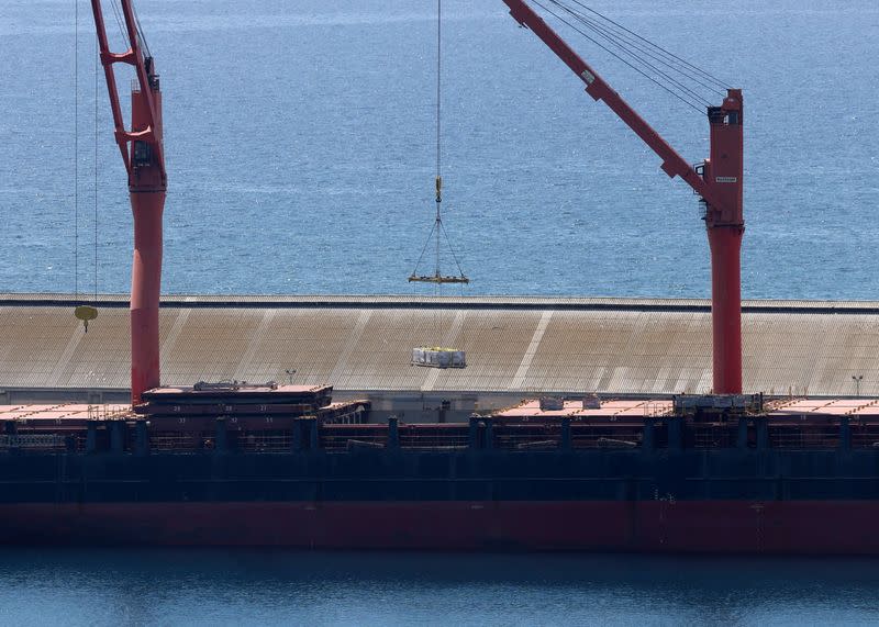 A crane lifts material onto a cargo vessel expected to take aid to Gaza from Cyprus, at the port of Larnaca