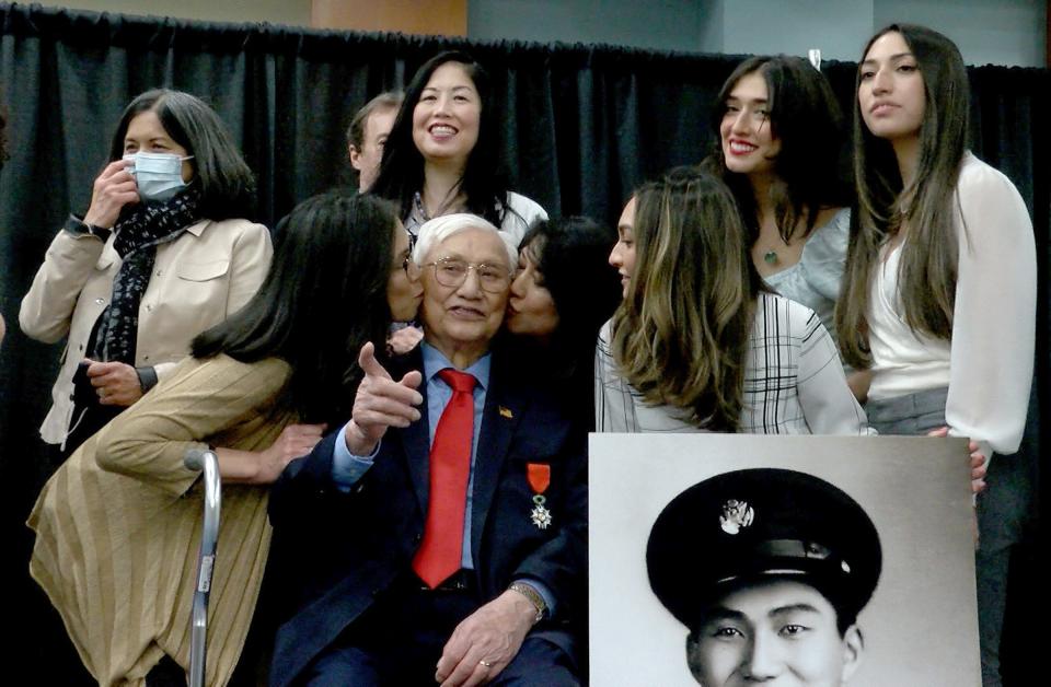 World War II veteran and retired United States Army Private First Class Edward L. Chan gets kisses from his daughters after he was awarded with the insignia of the French Legion of Honor during a ceremony at Brookdale Community College Wednesday, April 6, 2022.  The presentation was made by French Consul General in New York Jérémie Robert.