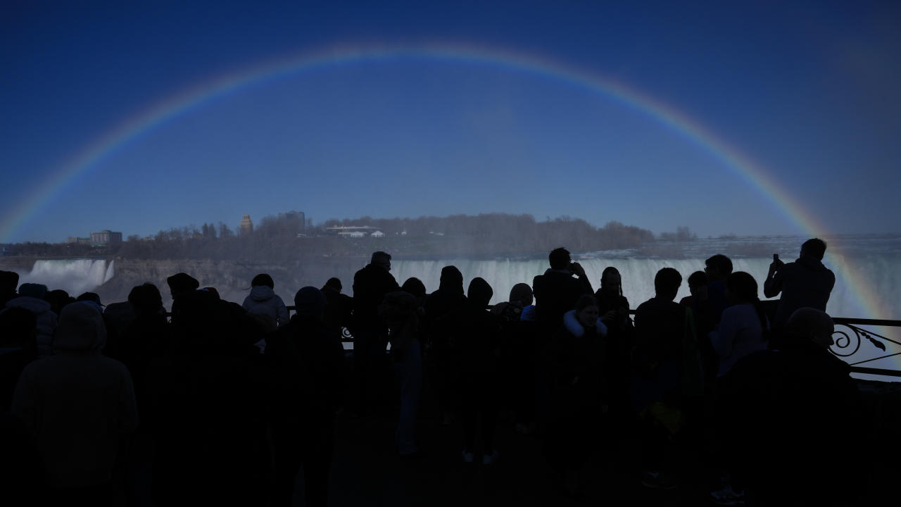 Mensen kijken naar een regenboog in de Niagara Falls.
