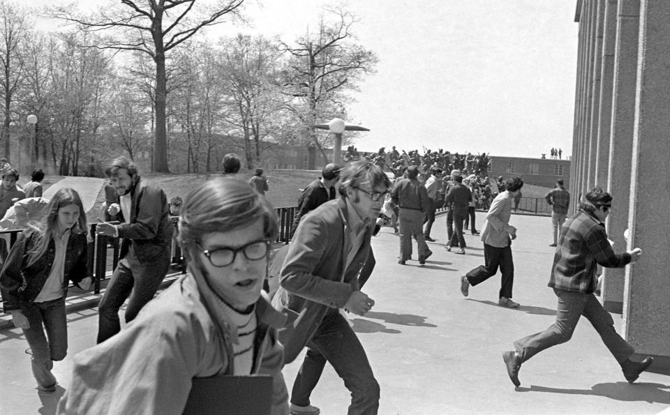Ohio National Guardsmen open fire on students at Kent State University on May 4, 1970, some of whom are fleeing for cover into Taylor Hall. Four students died and nine others were wounded during student protests against the Vietnam War. Clouds of dust at the far left of the photo near the sidewalk show bullets hitting the ground. The incident marked a pivotal moment in the public's perception of the Vietnam War, hastening the end of U.S. involvement. The Akron Beacon Journal's coverage of the Kent State shootings won the Pulitzer Prize for General Local Reporting. Akron Beacon Journal photo by Paul Tople PHOTO OF THE CENTURY SUBMISSION