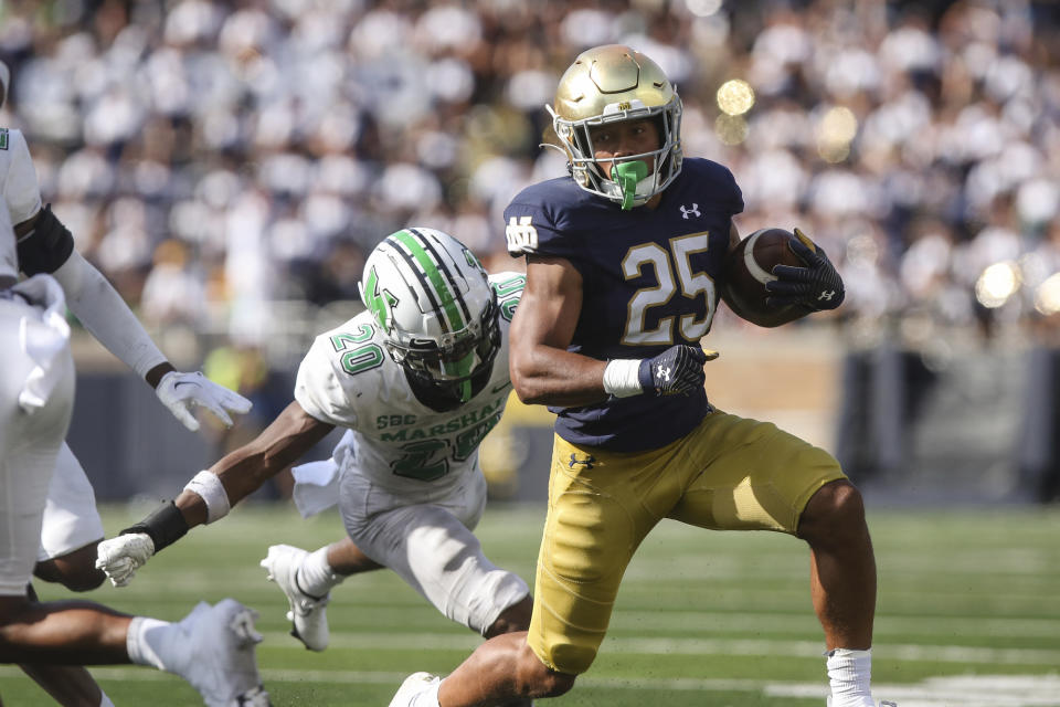 Marshall's Andre Sam (20) attempts to tackle Notre Dame running back Chris Tyree (25) during an NCAA college football game Saturday, Sept. 10, 2022, in South Bend, Ind. Marshall won 26-21. (Sholten Singer/The Herald-Dispatch via AP)