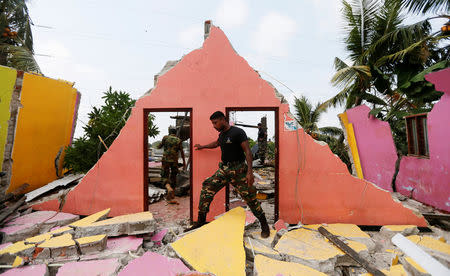 A member of the military inspects a damaged house for victims during a rescue mission after a garabage dump collapsed and buried dozens of houses in Colombo, Sri Lanka April 15, 2017. REUTERS/Dinuka Liyanawatte