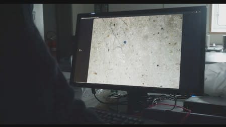 Microplastic found in ice core samples taken during the U.S.-led Northwest Passage Project is shown on a screen during an 18-day icebreaker expedition that took place in July and August 2019