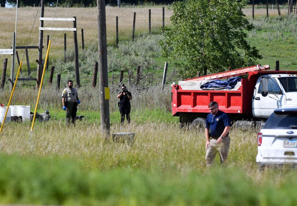 A law enforcement member photographs a truck on the property at a crime scene off of Highway 38 on Thursday, August 18, 2022, outside of Sioux Falls.