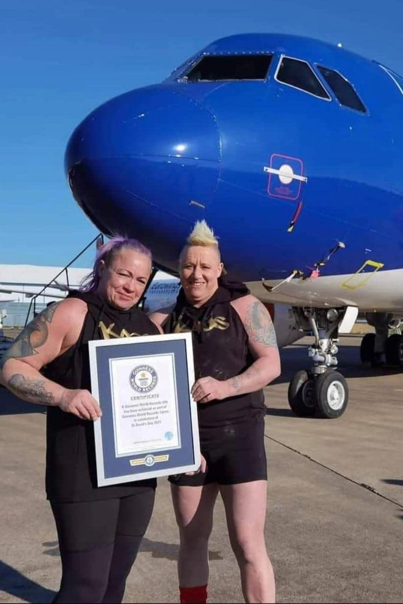 Sue Taylor-Franklin and her wife Sam in front of the plane they pulled for a world record