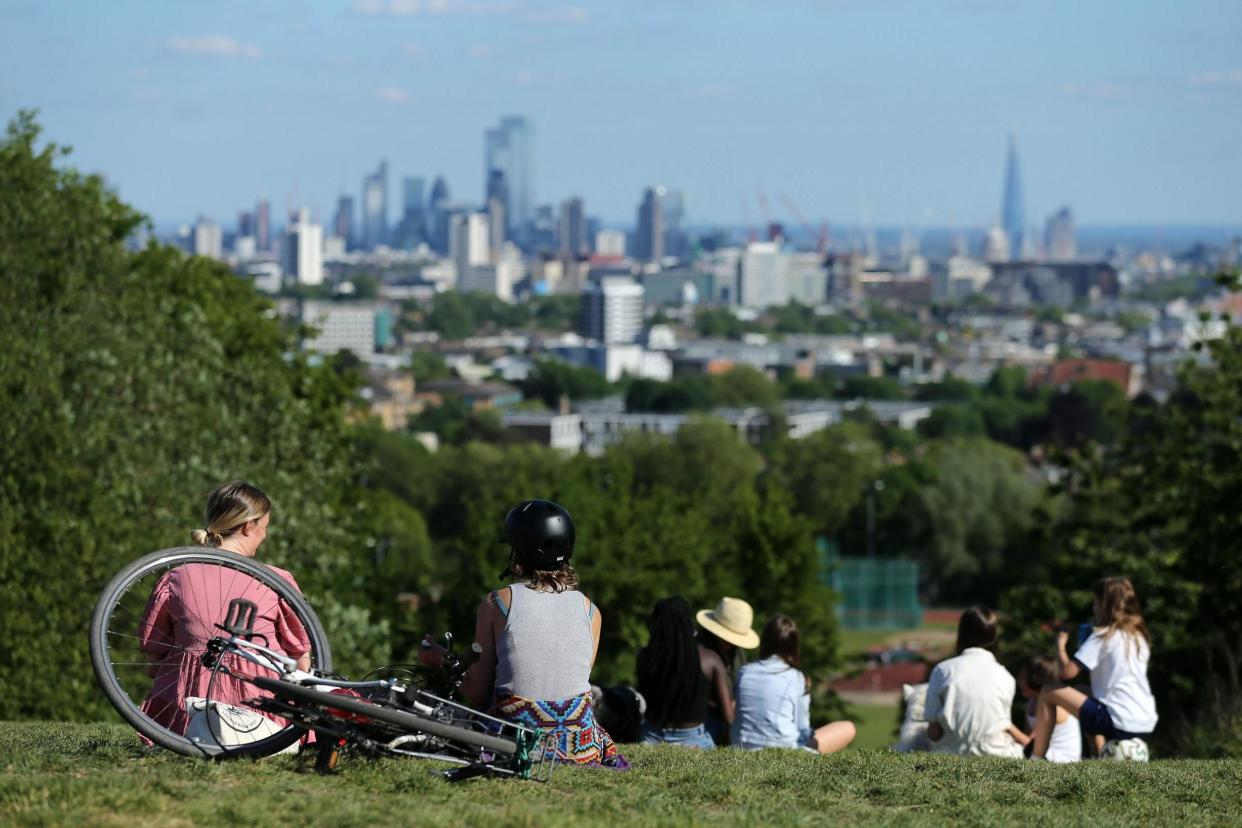 People walk in the afternoon sunshine on Hampstead Heath, north London: AFP via Getty Images