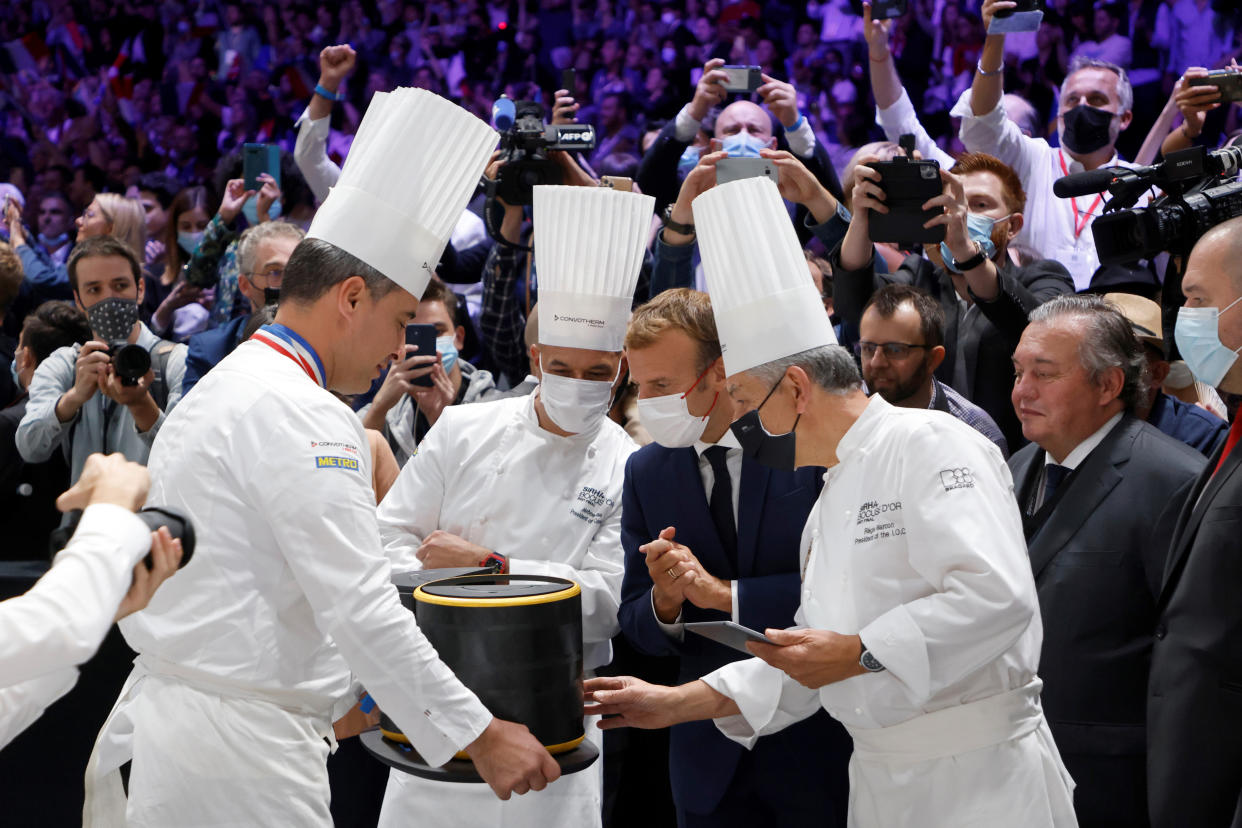 French President Emmanuel Macron, second right, looks at a lunchbox at the Bocuse d'Or gastronomy contest during the International Catering, Hotel and Food Trade Fair (SIRHA) in Lyon, central France, Monday Sept. 27, 2021. (Ludovic Marin, Pool Photo via AP)