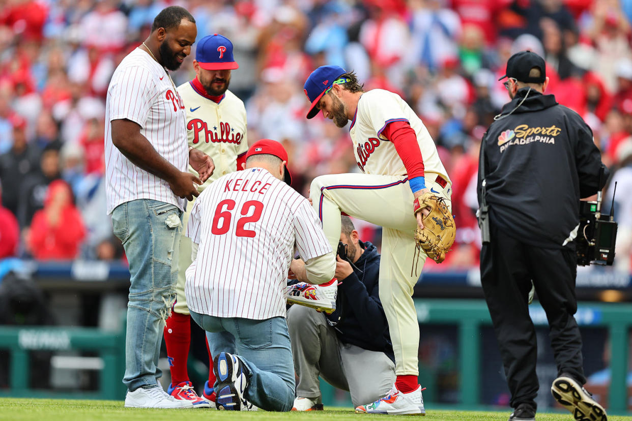 Jason Kelce former Philadelphia Eagle player throws out the ceremonial first pitch autographs the Under Armour cleat of Bryce Harper (3) of the Philadelphia Phillies prior to the game against the Atlanta Braves on March 30, 2024 at Citizens Bank Park in P (Rich Graessle / Icon Sportswire via Getty Images)