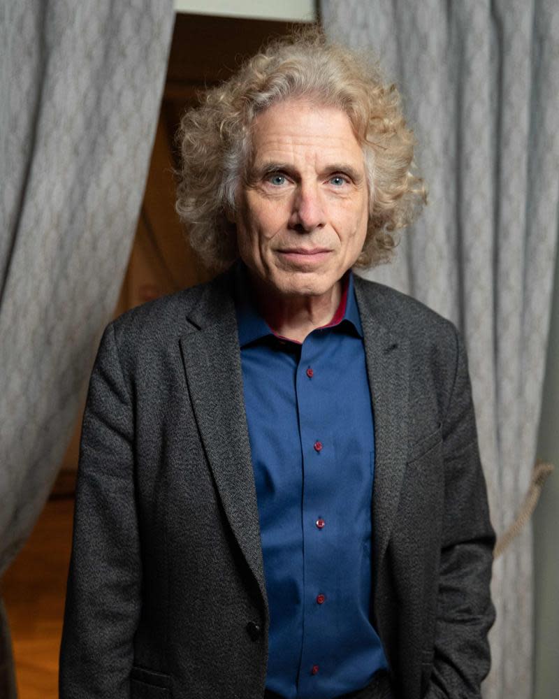 Portrait of Steven Pinker in a jacket and shirt with his hands in his pockets