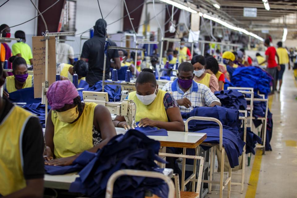 FILE - In this April 21, 2020 file photo, factory workers sew medical clothing and face masks at the Sonapi Industrial Park in Port-au-Prince, Haiti. The textile factory re-opened as part of a government financed effort to provide protective gear to medical workers amid the new coronavirus pandemic. (AP Photo/Dieu Nalio Chery, File)