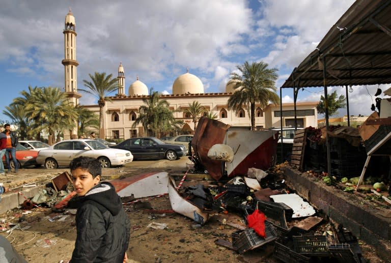 Libyans check the aftermath of an explosion in the eastern city of Benghazi on January 24, 2018