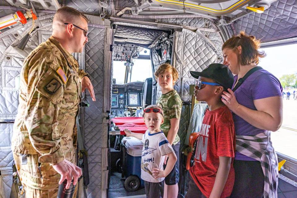 CW2 officer Fargher talks to, from left, Julian and Roman Roulette and Soloman and Angela Kull inside the Chinook Helicopter during the Scott Air Force Base Airshow on Saturday. The airshow drew thousands of spectators and included the MiG-17 Randy Ball; P-51 Mustang, Heritage Flight, F-22 Demo; Extreme Flight Pitts S1-S; as well as the Blue Angels. The airshow will continue Sunday.