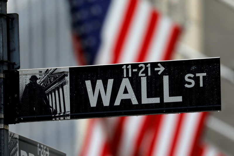 FILE PHOTO: Raindrops hang on a sign for Wall Street outside the New York Stock Exchange in New York
