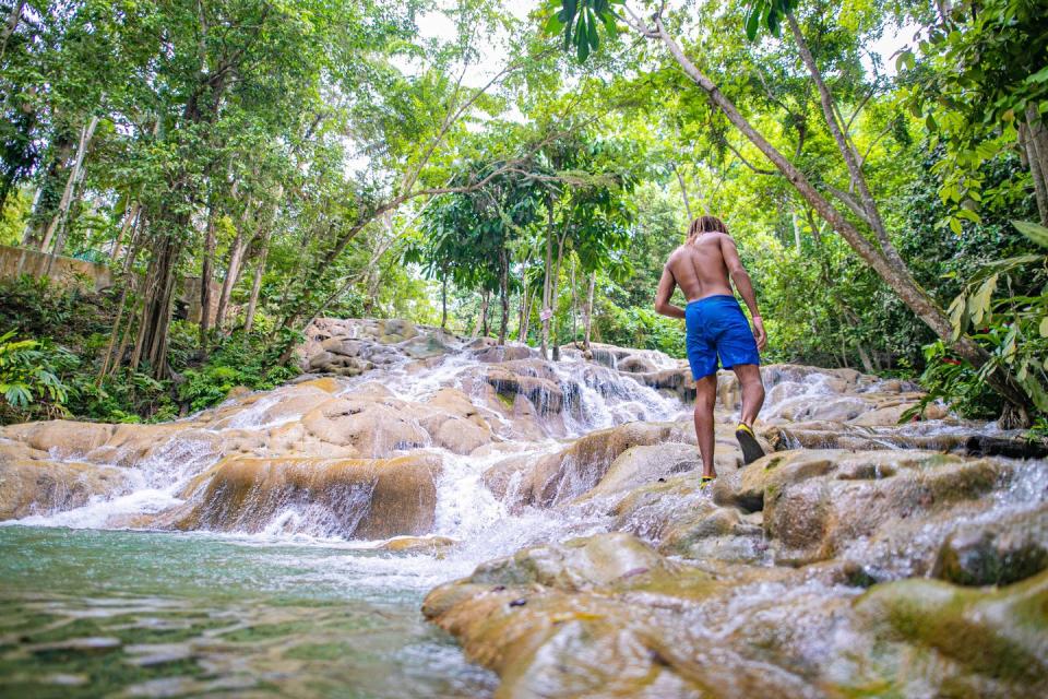 a man walking through ocho rios dunns river and waterfall