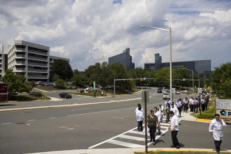 People evacuate near the building that houses Gannett and USA Today, Wednesday, Aug. 7, 2019, in McLean, Va. (AP Photo/Alex Brandon)
