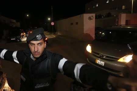 Jordanian policemen try to keep journalists out as a convoy carrying Japanese envoy State Minister for Foreign Affairs Yasuhide Nakayama leaves the Japanese Embassy after the news of the killing of Japanese hostage Kenji Goto in Amman January 31, 2015. REUTERS/Muhammad Hamed