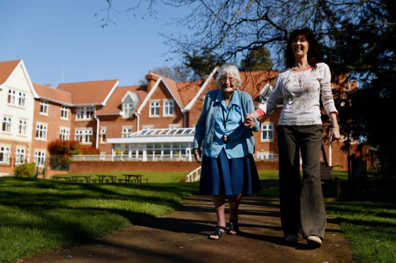 Resident Roche takes a walk in the grounds of Foxholes Care Home, assisted by activities director Davies