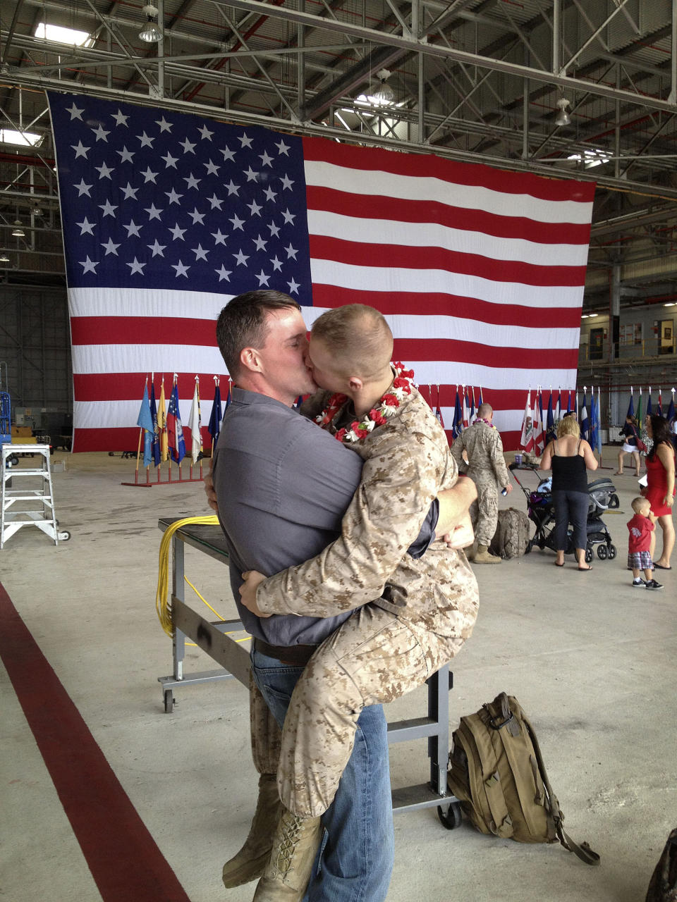 FILE - Sgt. Brandon Morgan, right, kisses his partner, Dalan Wells, in a helicopter hangar at the Marine base in Kaneohe Bay, Hawaii upon returning from a six-month deployment to Afghanistan on Wednesday, Feb. 22, 2012. The photo, made some five months after the repeal of the military's "don't ask don't tell" policy prohibiting gay servicemen from openly acknowledging their sexuality, was among the first showing a gay active duty serviceman in uniform kissing his partner at a homecoming. (AP Photo/David Lewis, File)