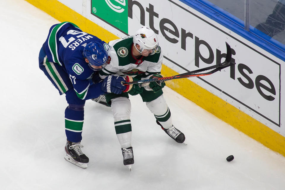 Vancouver Canucks' Tyler Myers (57) works against Minnesota Wild's Ryan Donato (6) during the third period of an NHL hockey playoff game Sunday, Aug. 2, 2020, in Edmonton, Alberta. (Codie McLachlan/The Canadian Press via AP)