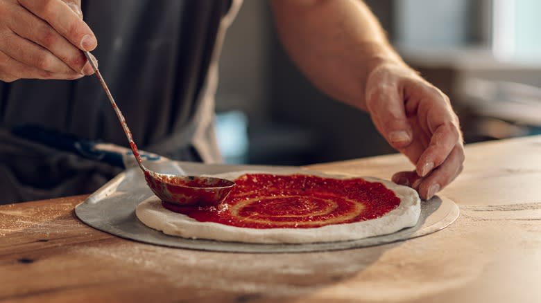 Person making pizza