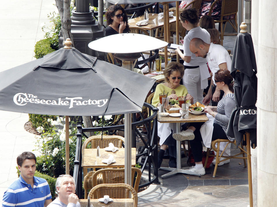 Patrons eat on a patio at The Cheesecake Factory restaurant  in Glendale, California April 19, 2011. Cheesecake Factory Inc.,  will release its earnings on April 20. The Cheesecake Factory is an upscale casual dining restaurant that offers approximately 200 items on its menu.  REUTERS/Fred Prouser (UNITED STATES - Tags: BUSINESS SOCIETY)