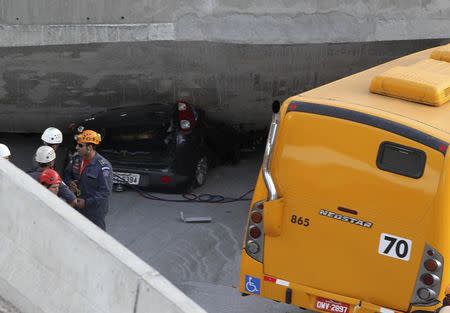 Rescue workers try to reach vehicles trapped underneath a bridge that collapsed while under construction in Belo Horizonte July 3, 2014. REUTERS/Carlos Greco-DYN