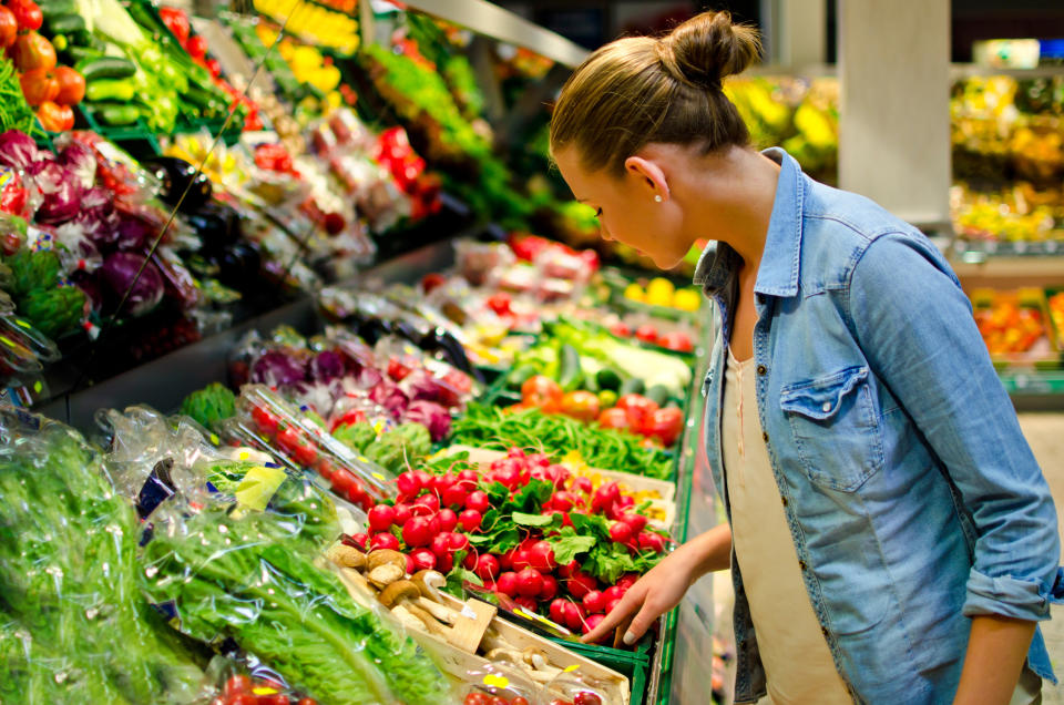 a woman shopping in the produce section of a grocery store