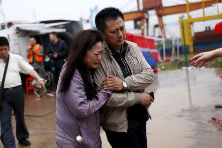 Relatives of a missing passenger aboard a capsized ship cry on the banks of the Jianli section of Yangtze River in Hubei province, China, June 4, 2015. REUTERS/Aly Song