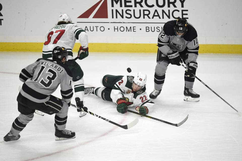 Minnesota Wild left wing Kevin Fiala, center, falls to the ice while battling for the puck with Los Angeles Kings center Trevor Moore, right, as Kings center Gabriel Vilardi, front left, and Wild left wing Kirill Kaprizov look on during the second period of an NHL hockey game in Los Angeles, Saturday, Jan. 16, 2021. (AP Photo/Kelvin Kuo)